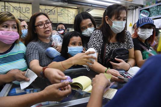 Mensen kopen mondmaskers in de Filipijnse hoofdstad Manilla.