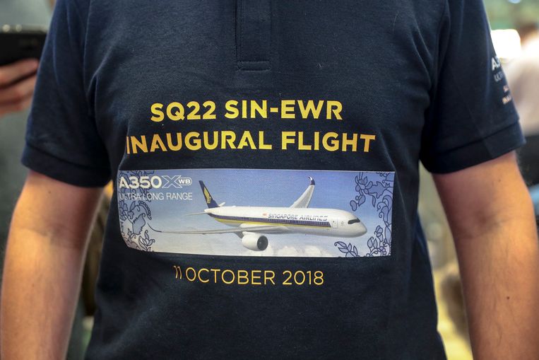 Een passagier heeft een speciaal bedrukt shirt aan ter ere van deze gedenkwaardige vlucht van Singapore naar New York. Beeld EPA