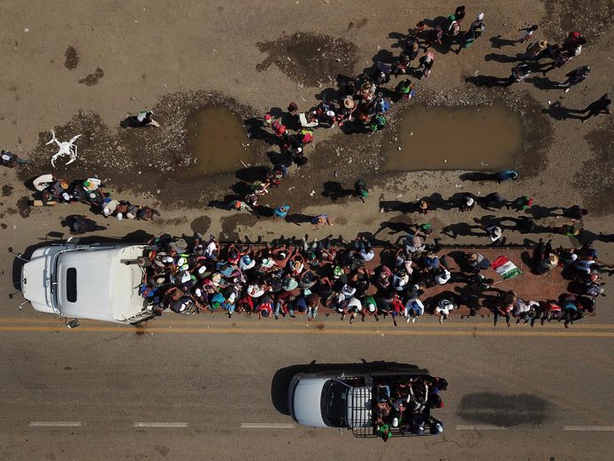 Deelnemers aan de migrantenkaravaan bevinden zich in Mexico en rijden even mee met een vrachtwagenoplegger.