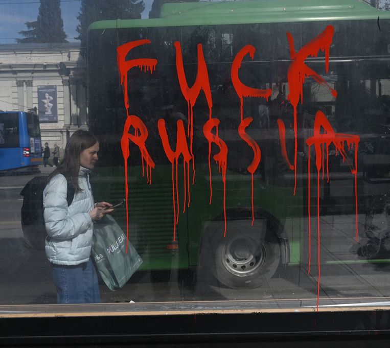 Een vrouw loopt langs graffiti met een boodschap aan het buurland.  Beeld AFP