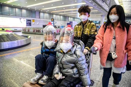 Kinderen met geïmproviseerde gezichtsbescherming op de luchthaven in Guangzhou.