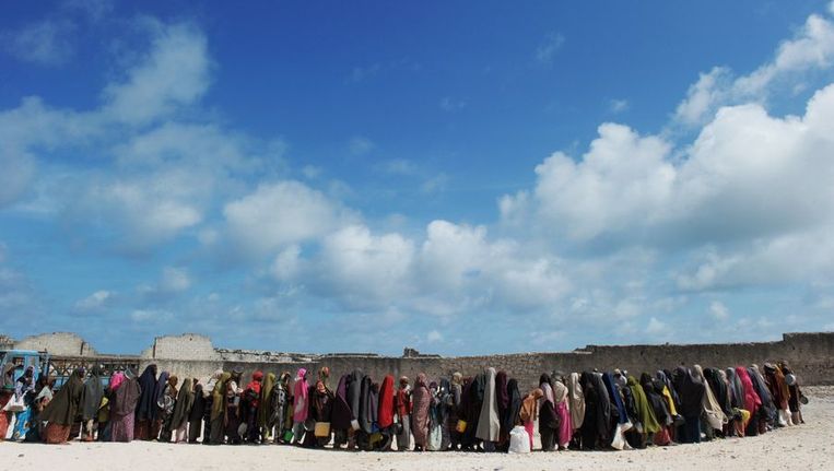 Vrouwen in een vluchtelingenkamp bij Mogadishu staan in de rij voor voedsel. Beeld afp