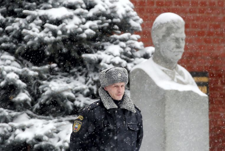 Een Russische militair staat voor een portret van Stalin bij zijn begraafplek. Beeld epa