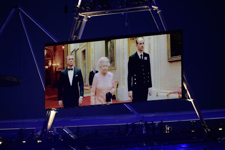 Elizabeth II met prins Philip, rechts, en James Bondacteur Daniel Craig tijdens de opening van de Olympische Spelen in 2012.   Beeld Getty Images