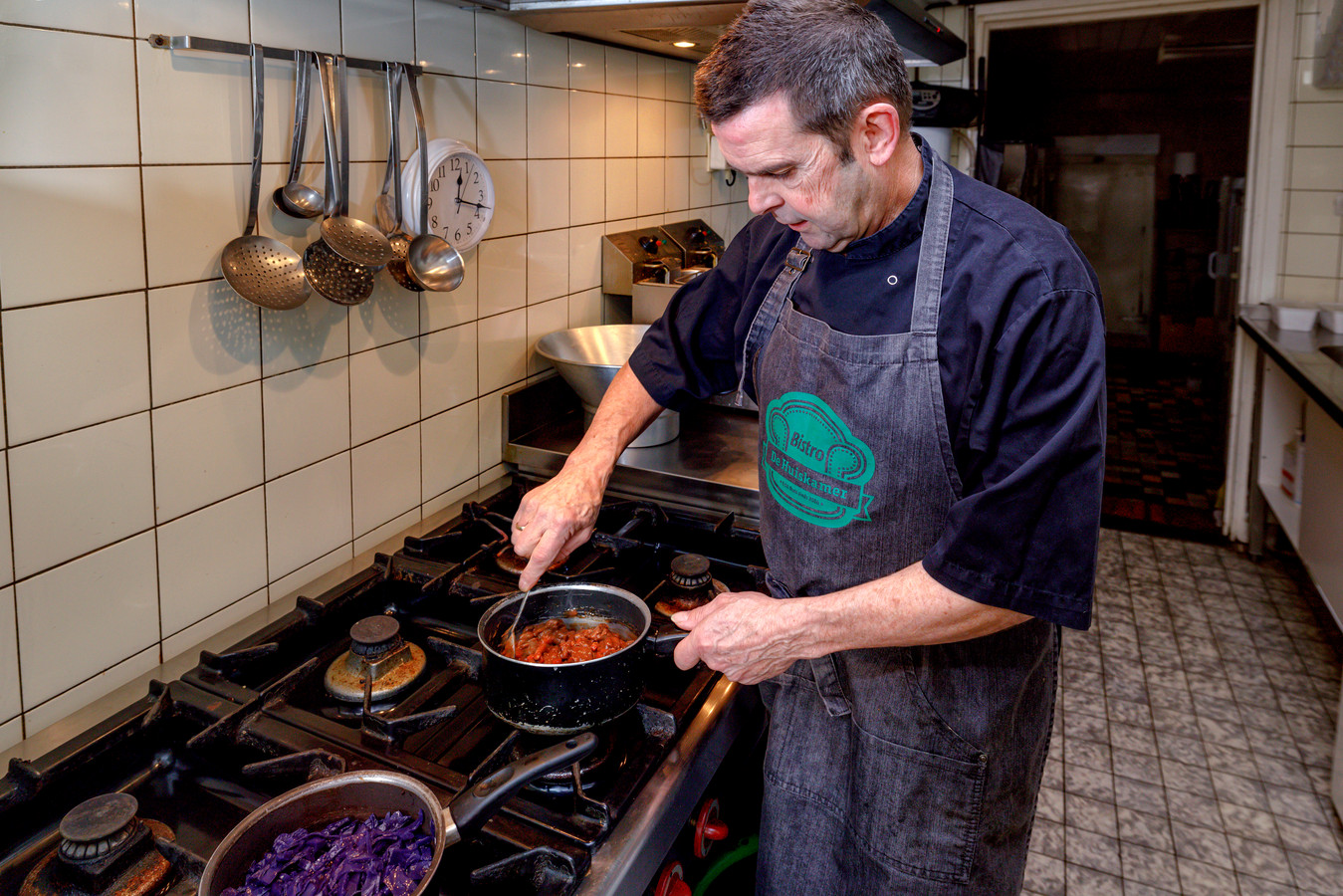 Chef Daan van Woensel staat in de keuken voor de afhaalmaaltijden en maakt hazenpeper met rode kool.