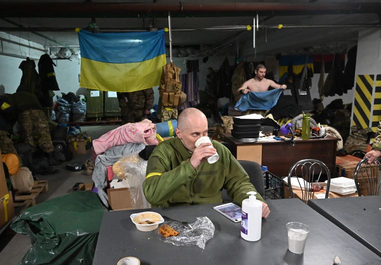 Een soldaat van de Territoriale Verdedigingstroepen van Oekraïne eet zijn lunch in een ondergrondse garage die is omgebouwd tot een training- en logistieke basis in Kiev.  Beeld AFP