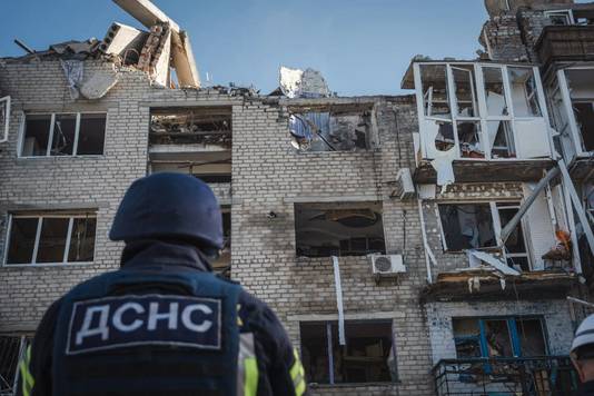 Een lid van de Oekraïense hulpdiensten overziet een door de raketaanval in Pokrovsk  zwaar beschadigd gebouw.