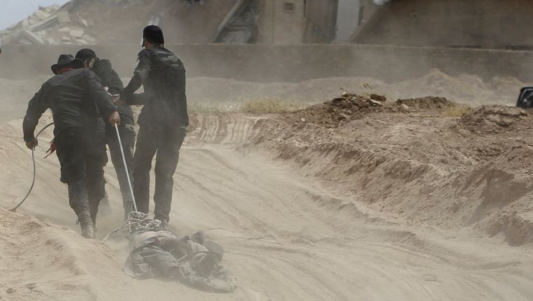 Sjiitische soldaten verslepen het lichaam van een IS-strijder. Beeld reuters
