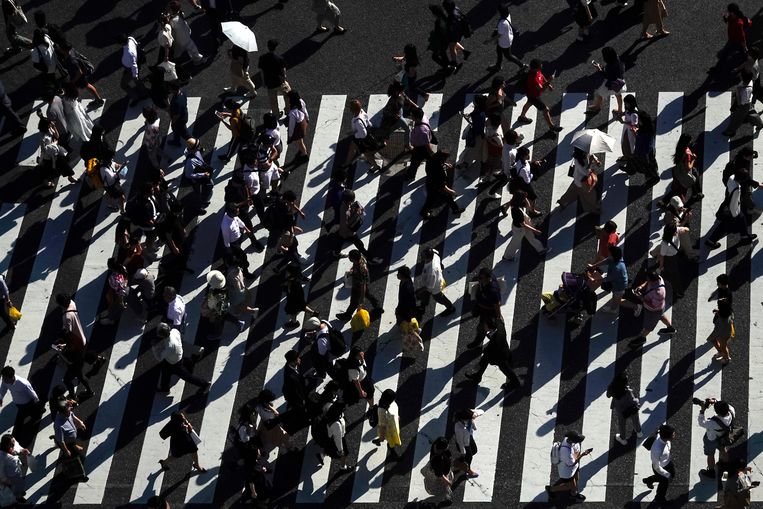 Voetgangers, al of niet met smartphone in de hand, steken over bij het beroemde Shibuya kruispunt in Tokio, Japan. Beeld AP