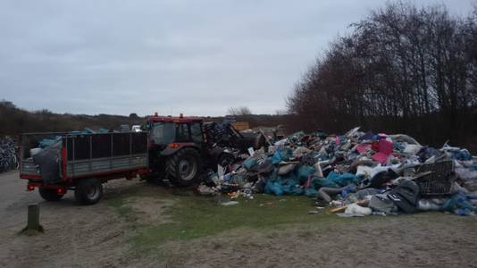 Bergen verzameld afval liggen bij de strandopgangen