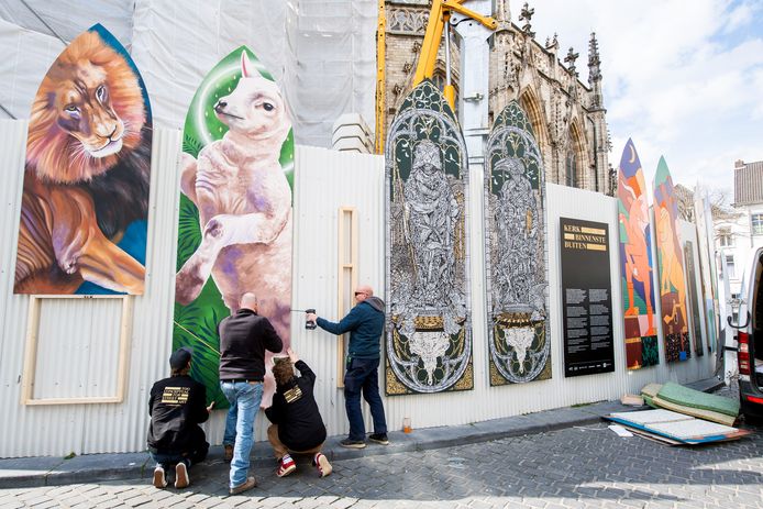 Medewerkers Blind Wall Gallery bevestigen de 'poten' onder het werk van Nina Valkhoff aan de Grote Kerk. Ernaast het nieuwe werk van MonkeyBird Crew