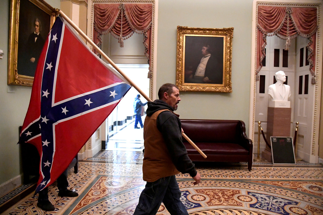 Een aanhanger van Trump liep woensdag met de Confederatievlag door het Capitool. Beeld Reuters