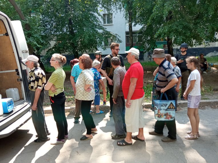 Parlementslid Svjatoslav Joerasj (midden) deelt met zijn medewerkers hulpgoederen uit in Lysytsjansk. Beeld DPG/Jan Hunin