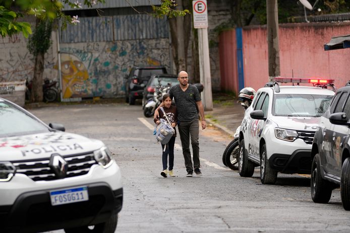 Een meisje wordt opgehaald door haar vader nadat een leerling een 71-jarige leerkracht doodstak met een mes en drie andere leraren en twee medeleerlingen verwondde op een school in Sao Paolo.