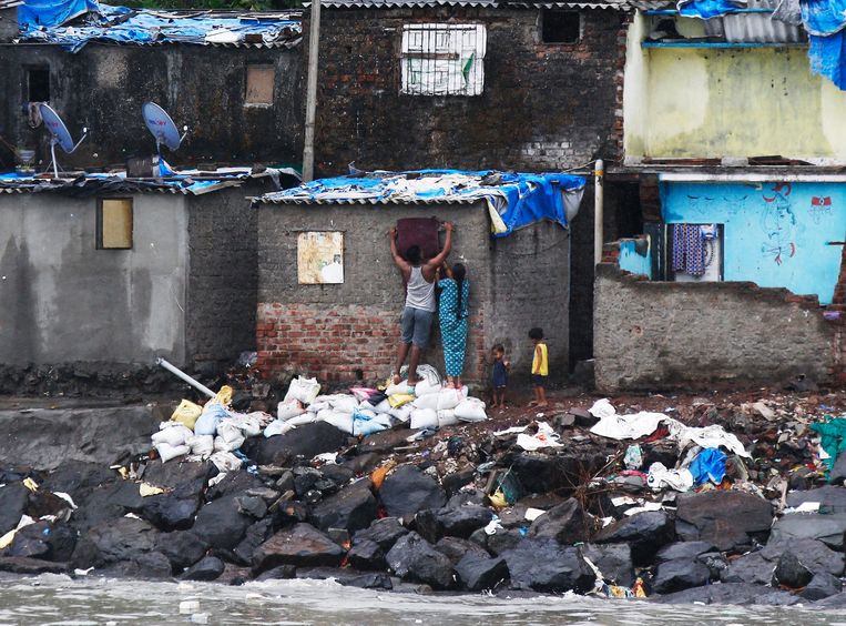 Vissers aan de kunst proberen hun huizen zo goed mogelijk te beschermen voor cycloon Nisarga.  Beeld AP