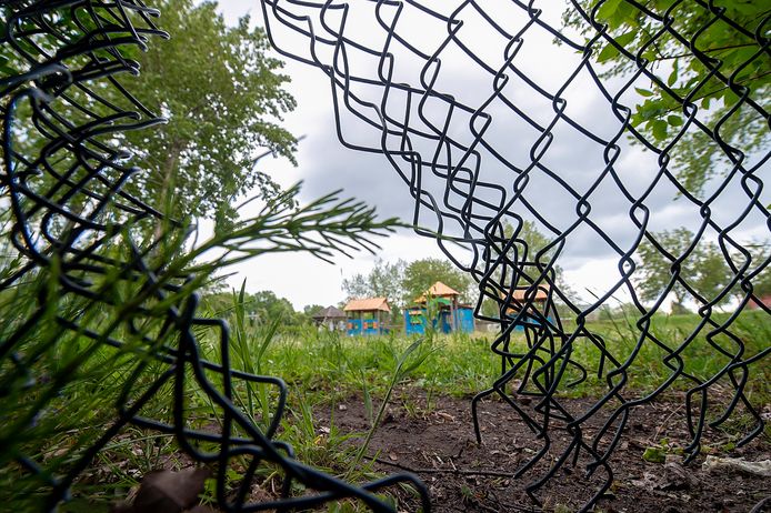 Bergen op Zoom Pix4Profs / Marina Popova. 
Kinderen klimmen door een gat in de hek om in de speeltuin te komen.