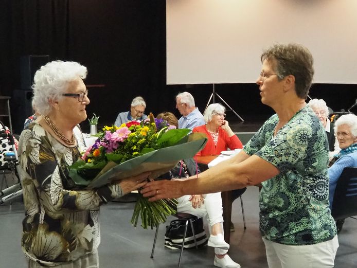 Oprichter en oud-voorzitter Annie Kraaykamp van de plaatselijke Zonnebloem (links) wordt in de bloemetjes gezet door Ria van Luijk die nu voorzitter van de afdeling Engelen/Bokhoven is.