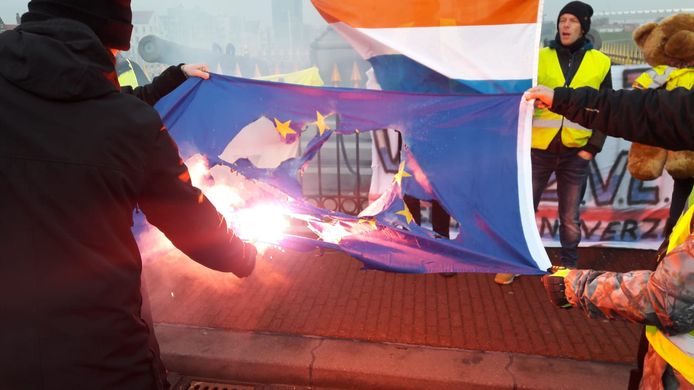 Een vlag van de Europese Unie wordt in brand gestoken.