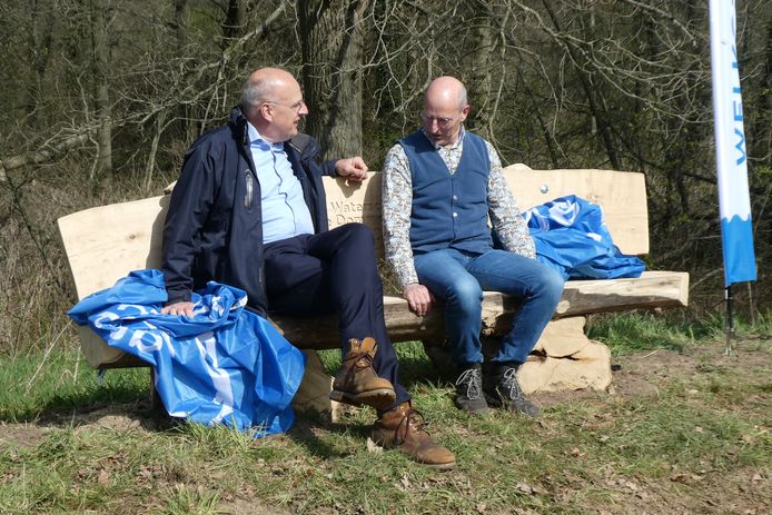 Vincent Lokin (waterschap, links) en Toon Loonen (Natuurmonumenten) proberen de nieuwe bank uit, met uitzicht op de Beerze.