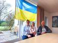 Anna, Milana en Hugo in het huis waar ze samen negen maanden woonden en de Oekraïense vlag een prominente plek krijgt.