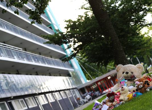 Bloemen en knuffels liggen op de plek onderaan de flat waar het levenloze lichaam van het achtjarige meisje Sharleyne werd aangetroffen.