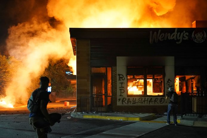 Demonstranten bij het brandende Wendy's restaurant, waar dit weekend een zwarte man werd doodgeschoten door de politie.