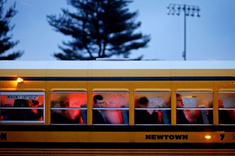 Een schoolbus vervoert bezoekers naar de Newtown High School, waar een herdenkingsdienst zal worden gehouden die wordt bijgewoond door president Obama. Beeld ap