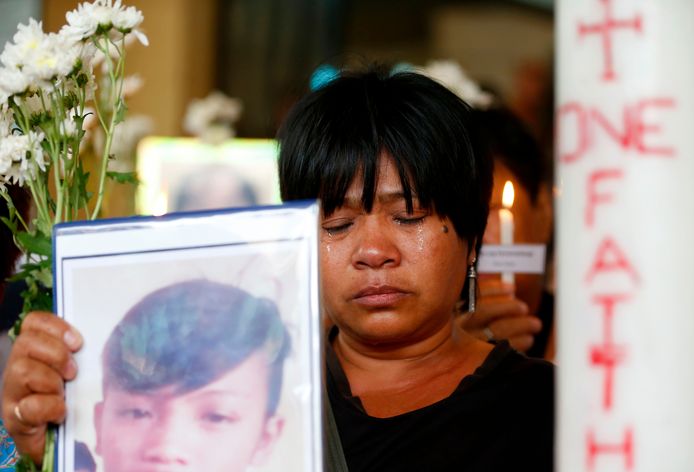Een vrouw houdt tijdens een katholieke mis in Quezon in het noordoosten van Manila het portret omhoog van een dierbare die het slachtoffer geworden is van Dutertes nietsontziende drugsoorlog.