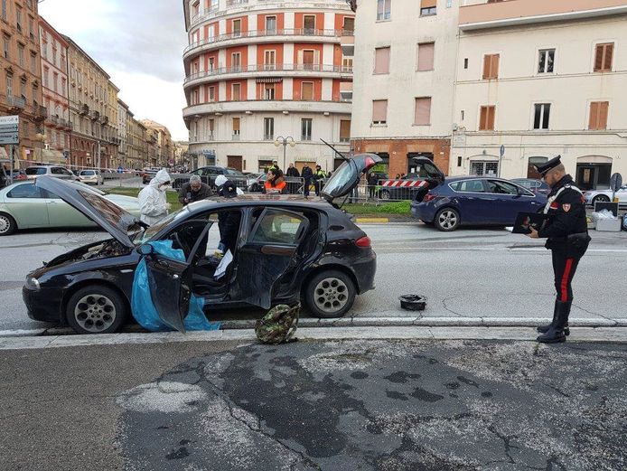 De auto van Luca Traini wordt doorzocht na de schietpartij.
