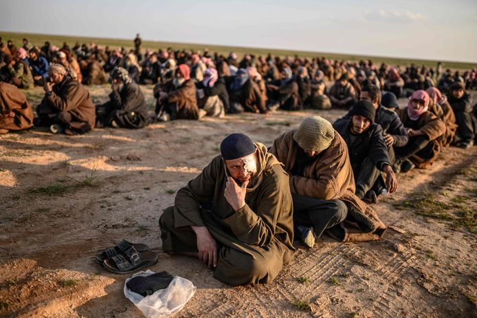 Mannen die ervan verdacht worden IS-strijder te zijn, wachten op hun ondervraging door Syrische strijdkrachten.
