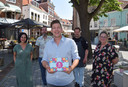 Initiatiefnemer Robert de Ruijter van Munt aan Zee met achter hem (vlnr) een boekhandelaar, een barbier, een slager en een theehuisuitbater die de munt accepteren.