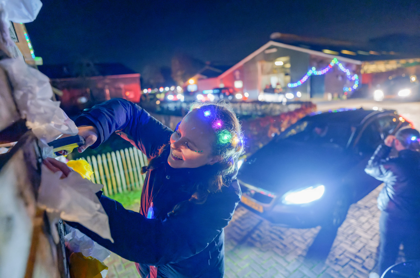 Iedere deelnemer vouwt een roosje van een servet. En zo groeit de boog in de lichtjesroute gestaag.
