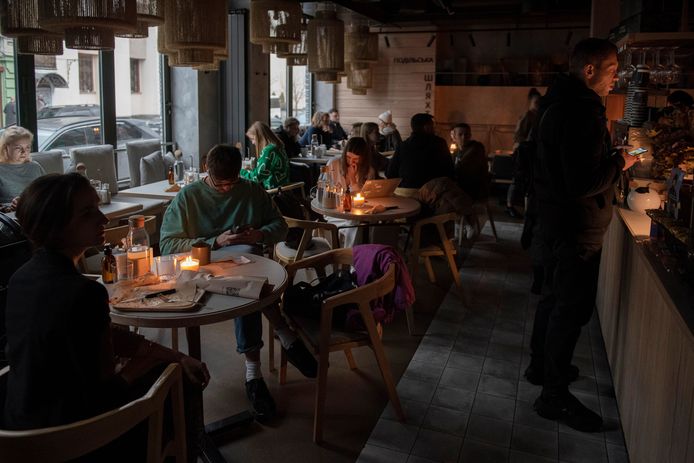 Klanten zitten op café in Kiev met kaarslicht