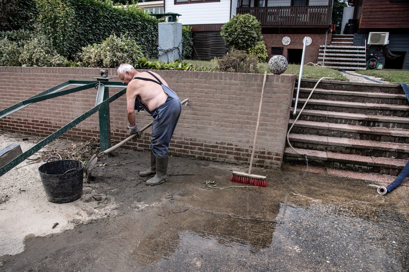 Heinz Goy is net aangekomen bij zijn vakantiechalet pal aan de Maas in Maashees. Hij maakt zijn ondergelopen kelder en achtertuin schoon.