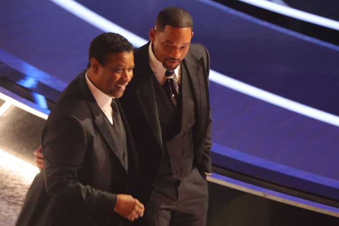 Denzel Washington (links) praat in een reclamepauze even met Will Smith na de klap die hij gaf aan Chris Rock