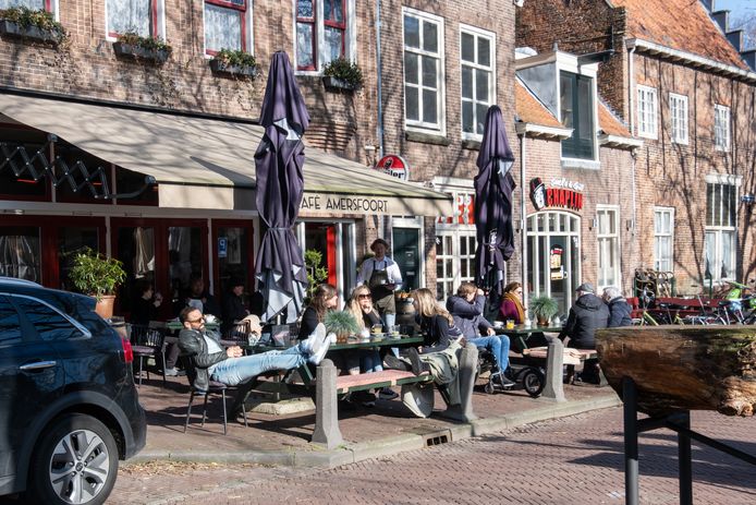 Voor bij Stadscafé Amersfoort genieten mensen van een drankje in de zon.