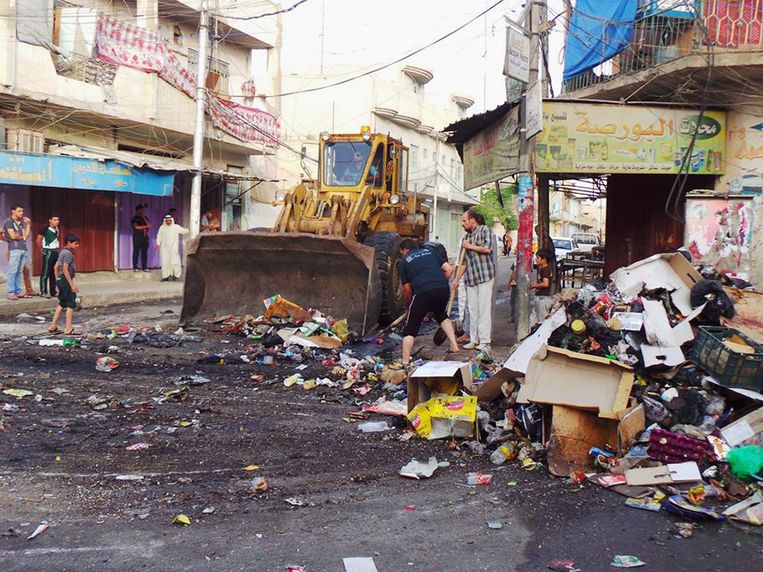Een straat in Mosul wordt met een bulldozer schoongeveegd. Beeld ap