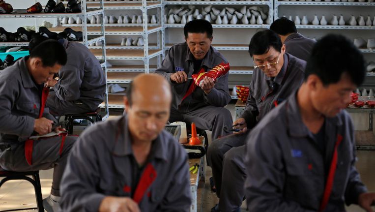 Noord-Koreaanse dwangarbeiders in een schoenenfabriek in China. Beeld reuters