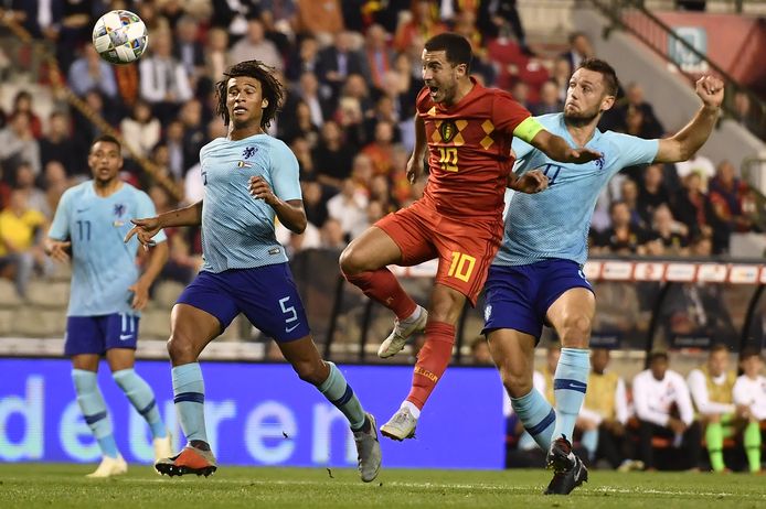 Met De Vrij in zijn rug, kopt Eden Hazard in de jongste België - Nederland (1-1) op doel. Aké kijkt toe.