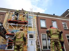 Omstanders blussen dakbrand met tuinslang 