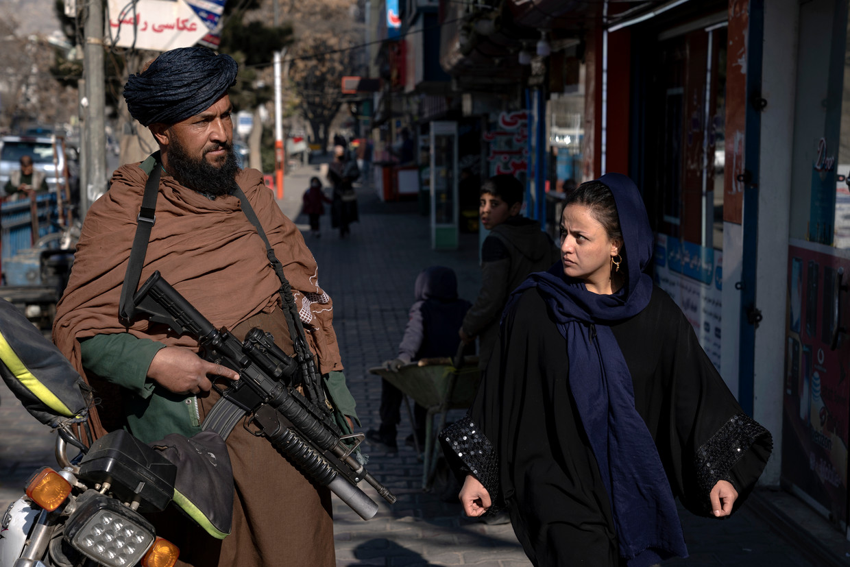 Een talibanstrijder en Afghaanse vrouw in Kaboel. Sinds de machtsovername vorig jaar zijn vrouwenrechten in Afghanistan steeds verder ingeperkt.  Beeld AP / Ebrahim Noroozi