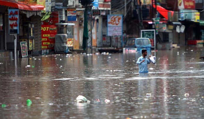 Illustratiebeeld: een man in het water tijdens overstromingen in  Rawalpindi, Pakistan op 13 juli 2022.