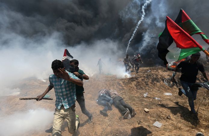 Palestijnse betogers verschuilen zich of lopen weg wanneer Israëlische soldaten het vuur openen.