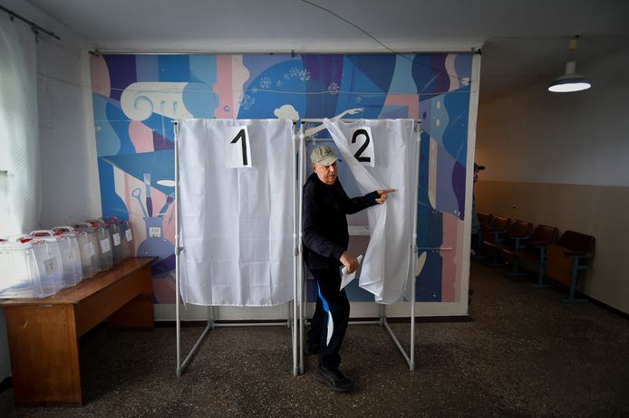 Un homme tient son bulletin de vote alors qu'il quitte un isoloir dans un bureau de vote lors d'un référendum à Melitopol, dans la région de Zaporijjia, dans le sud de l'Ukraine, le mardi 27 septembre 2022.