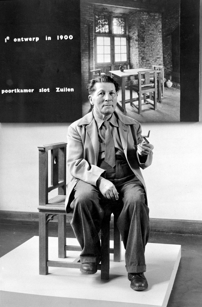 Rietveld in 1959 op de stoel uit Slot Zuylen met in zijn hand de zigzagstoel. Beeld TRBEELD