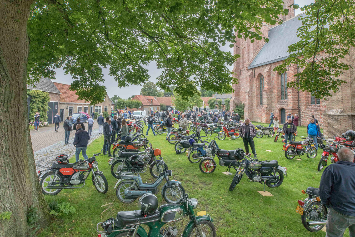 150 Oldtimer-brommers trekken de aandacht onder de kerk van Nisse