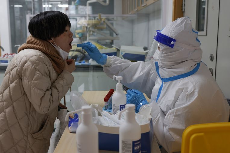 Een vrouw wordt getest op het coronavirus in Peking.  Beeld Getty Images