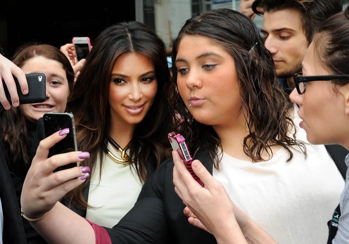 Kim Kardashian maakt een selfie met wat fans.