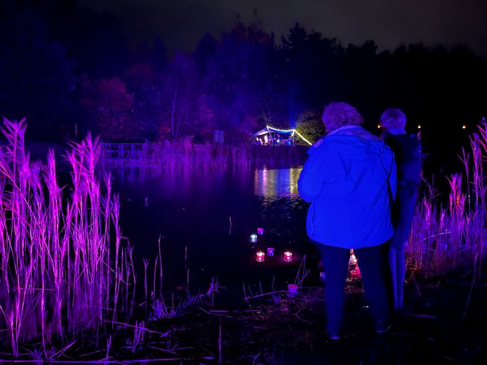 Maria Raaijmakers en Margiet van der Linden leggen een drijfkaarsje in het water van de fraai uitgelichte vijver.