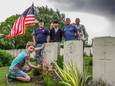 Comander Joseph Schram en andere leden en vrijwilligers van het American Legion  plaatsen een Amerikaanse vlag bij een grafsteen.